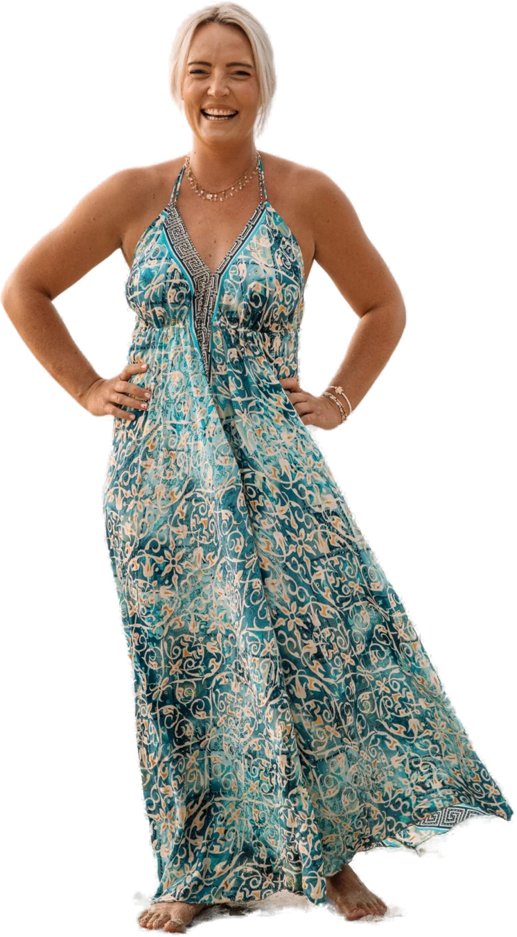 Sam, owner of Ever After Events, laughing on a beach in a turquoise patterned dress